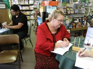 Edward Gonzales and Donna Le signing books for customers